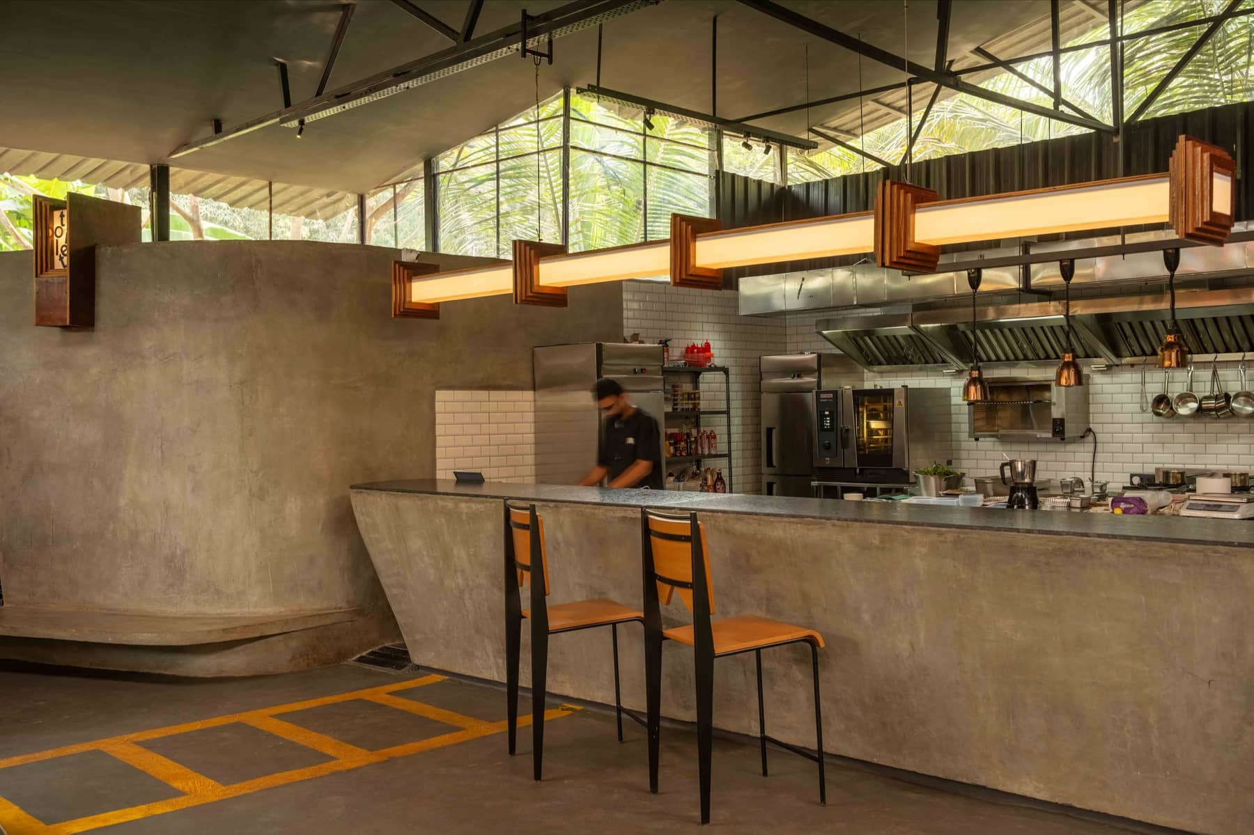 The open kitchen at The Foundry Nagoa, seen across the concrete pass under the warehouse roof