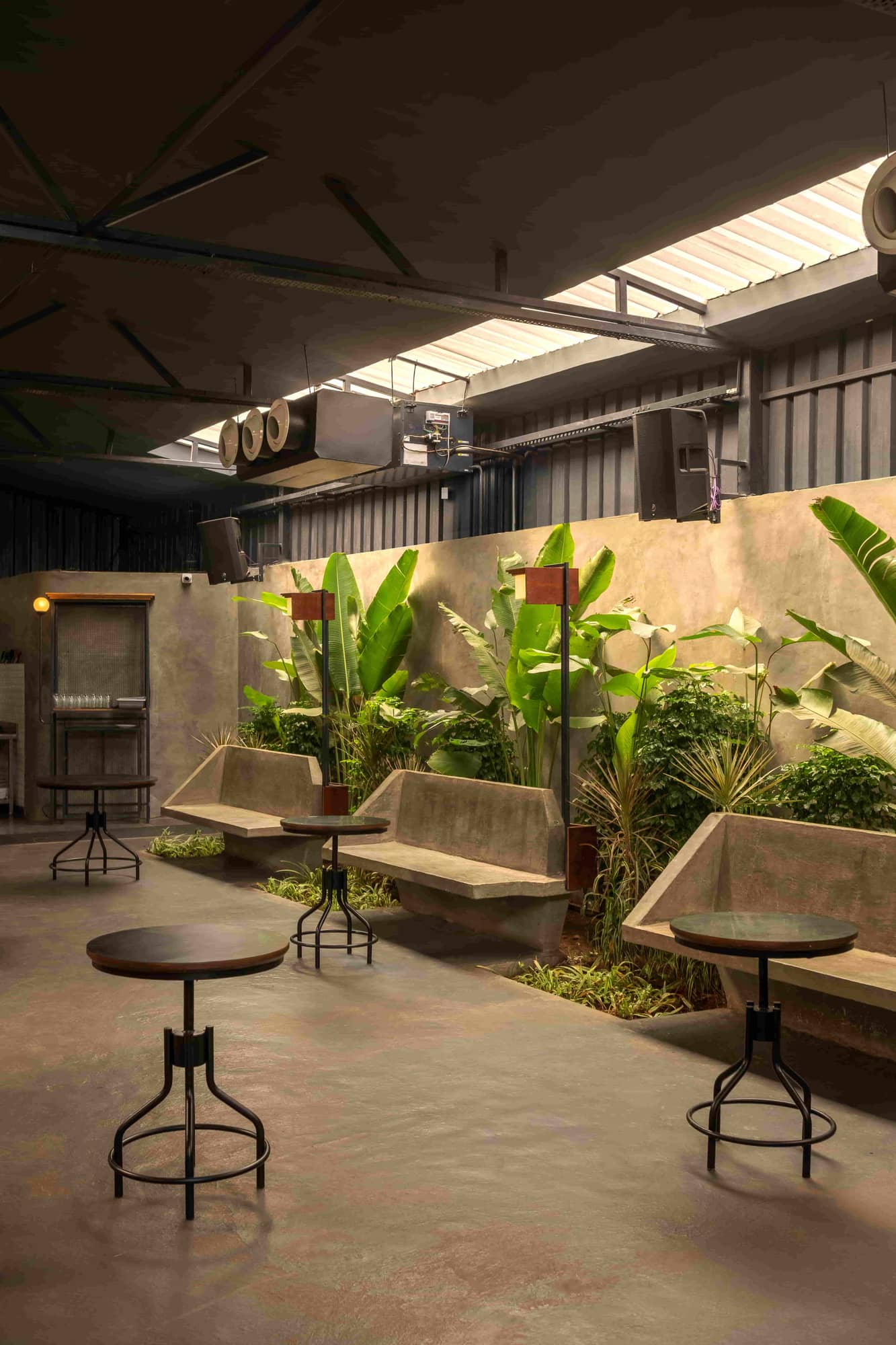 Inside The Foundry Nagoa: cast concrete benches and a long indoor planter under the warehouse skylight